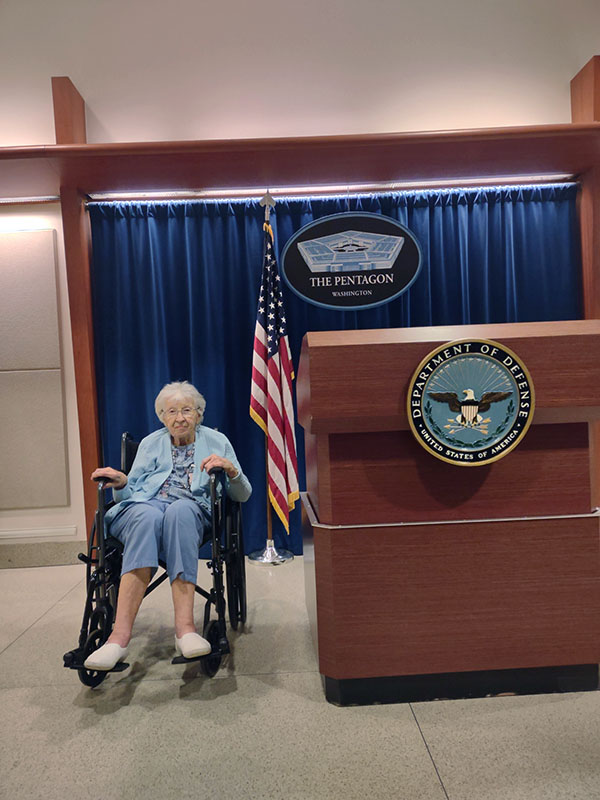 Mrs. Josephine Ann Talipin Gazelle in her wheelchair posing next to a Pentagon podium